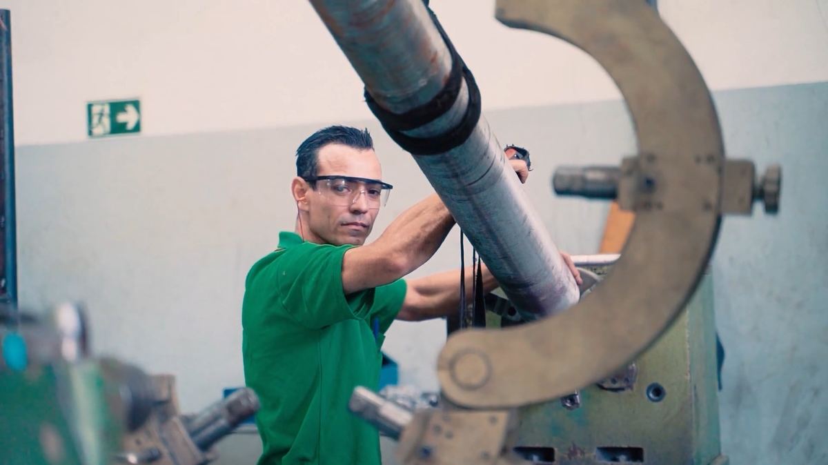 Operador ajustando uma peça na máquina