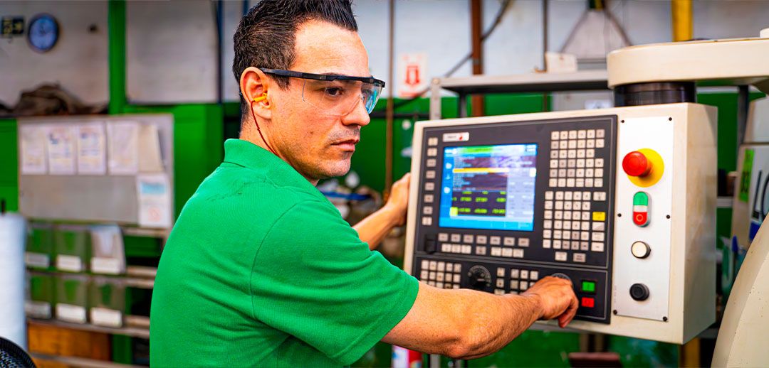 Operador programando a máquina no chão de fábrica